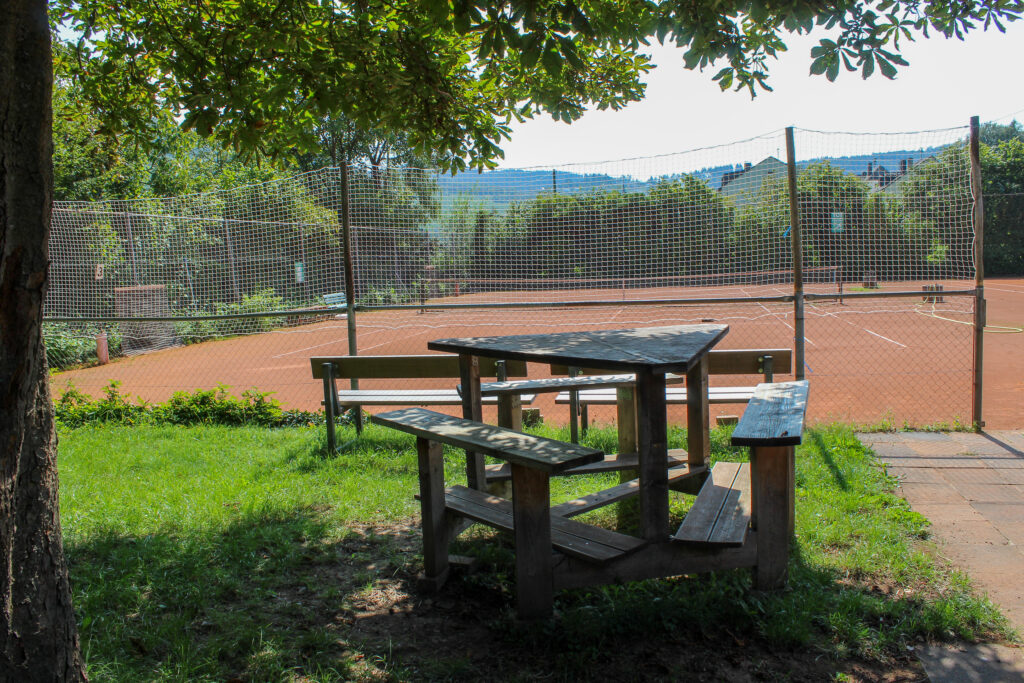 Die Sitzmöglichkeiten hinter den zwei nebeneinander liegenden Tennisplätzen.